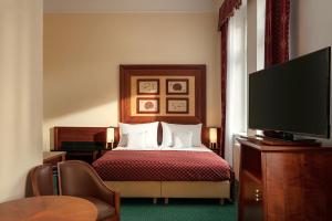 a hotel room with a bed and a flat screen tv at Villa Smetana Spa & Wellness Resort in Karlovy Vary
