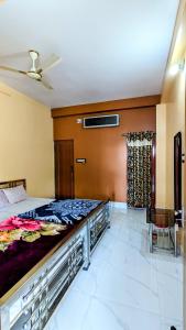 a bedroom with a bed and a ceiling fan at Sundarban Tulip Homestay, Pakhiralay, WB in Purbbadulki