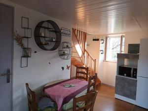 a small dining room with a table and a staircase at La maison des vignes in Clairvaux-dʼAveyron