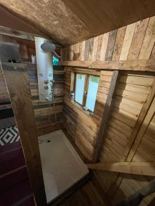 un ampio bagno in legno con doccia e finestra di Hebergement insolite, Location Yourte au bord du lac de mielan a Miélan