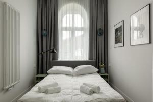 a bedroom with a bed with two towels on it at Apartament Majowy w Centrum Kudowy in Kudowa-Zdrój