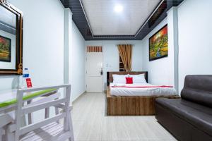 ein Schlafzimmer mit einem Bett und einem Sofa in einem Zimmer in der Unterkunft RedDoorz near Universitas Simalungun Pematangsiantar in Pematangsiantar