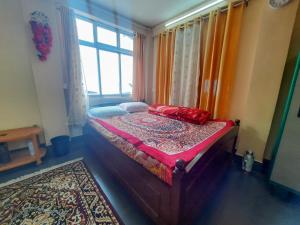 a bedroom with a bed in a room with a window at Neora Backpackers Hostel in Darjeeling