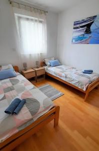 two beds in a room with wooden floors at Apartment Paklina in Starigrad-Paklenica