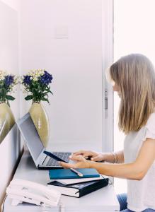 a woman sitting at a desk with a laptop computer at River View Boutique Apts in Ayia Napa