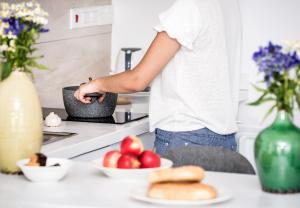 a person standing in a kitchen with apples and bread at River View Boutique Apts in Ayia Napa