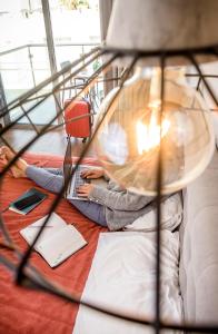 a person sitting on a bed with a laptop at River View Boutique Apts in Ayia Napa