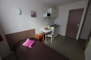 Habitación pequeña con cama con almohada rosa en Hôtel du Roussillon, en París