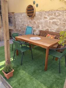 una mesa de madera y sillas en un patio en Casa rural El olivo, en Puigmoreno