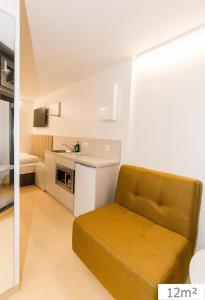 a living room with a couch and a kitchen at Smart Nano Living - Wien Hauptbahnhof in Vienna