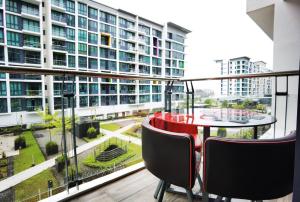 - un balcon avec une table et des chaises rouges et un grand bâtiment dans l'établissement Jeff and Ricky Homestay 11 @Vivacity Megamall, à Kampong Tabuan