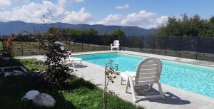 una piscina con 2 sillas de jardín junto a ella en HOTEL PIORNEDO, en Lugo