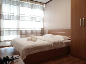- une chambre avec un lit doté de draps blancs et une fenêtre dans l'établissement Jeff and Ricky Homestay 11 @Vivacity Megamall, à Kampong Tabuan