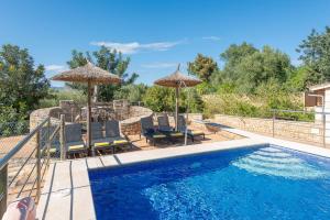 a swimming pool with chairs and umbrellas next to a pool at Sa Cova - Alcúdia in Alcudia