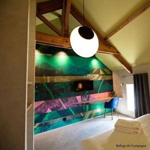 um quarto com uma pintura na parede em L'authentik petit hôtel Le Refuge de Mamie Yo 