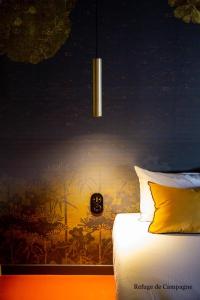 um quarto com uma cama com um quadro na parede em L'authentik petit hôtel Le Refuge de Mamie Yo 