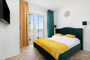 1 dormitorio con 1 cama grande con manta amarilla en Vola Palace, en Varsovia