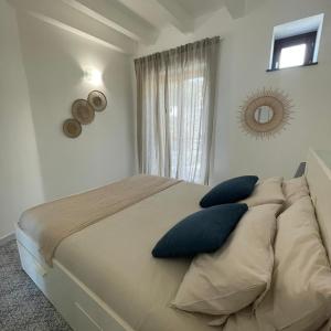 una camera da letto con un grande letto con cuscini blu di Casa Grazia Apartments a Città di Lipari