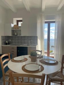 una cucina con tavolo, sedie e ampia finestra di Casa Grazia Apartments a Città di Lipari