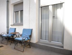 due sedie e un tavolo accanto a una finestra di Studio Milan a Vračar (historical)