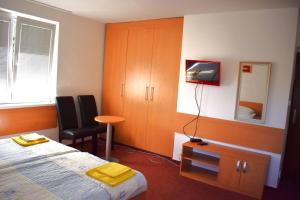 um quarto com uma cama, uma secretária e uma cadeira em Penzion Era em Zlín