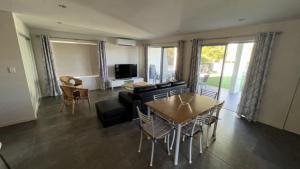 a living room with a table and chairs and a television at 1 - 5a Coochin Street, Dicky Beach - 200m To Beach in Caloundra