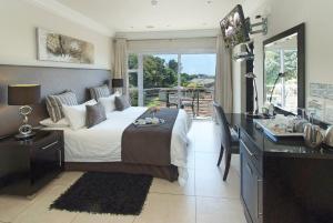a bedroom with a bed and a desk with a desk at uShaka Manor Guest House in Durban