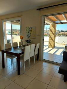 a dining room with a table and chairs and a balcony at Pyla Palms Resort B1 204 in Pyla