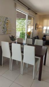 a dining room with a table and white chairs at Pyla Palms Resort B1 204 in Pyla