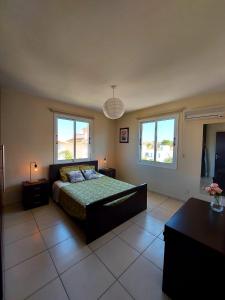 una camera da letto con un letto e due finestre di Pyla Palms Resort B1 204 a Pyla