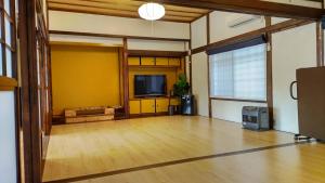 een lege woonkamer met een flatscreen-tv bij ドッグラン併設 しまなみ御殿 in Imabari