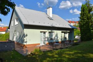 una casa bianca con tetto e sedie grigi di Penzion Era a Zlín