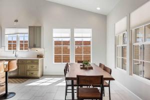 uma cozinha com mesa, cadeiras e janelas em The Wanderer home em Hurricane