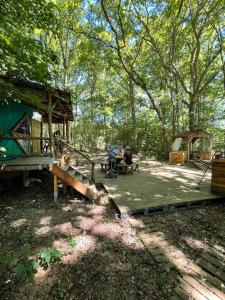 eine Gruppe von Menschen, die an einem Picknicktisch in der Nähe eines Zeltes sitzen in der Unterkunft Hebergement insolite, Location Yourte au bord du lac de mielan in Miélan