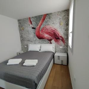 a bedroom with a bed with a pink flamingo mural at L'Alba dei Pescherecci in Chioggia