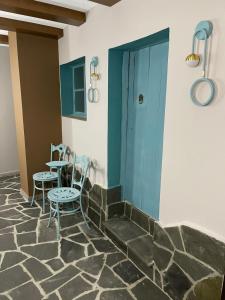 Habitación con mesa, sillas y puerta azul en Palorto Hotel, en Gjirokastra