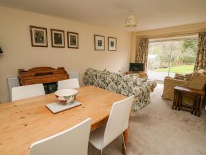 a living room with a wooden table and a couch at Salmon Cottage in Llanwrthwl