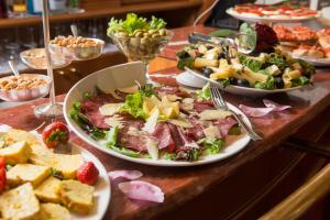 uma mesa coberta com pratos de comida e aperitivos em Hotel Berna em Milão