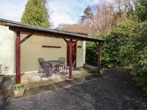 a patio with a table and chairs on it at Salmon Cottage in Llanwrthwl