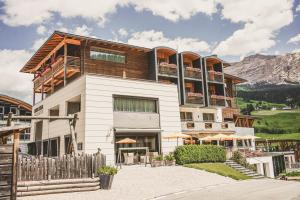 a large building with a fence in front of it at Hotel Ciasa Soleil in La Villa