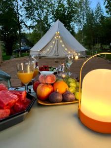 a table with fruit and drinks and a tent at Glamping Žvaigždžių slėnyje 