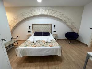 a bedroom with a large bed in a room with an arch at Apartamentos Living Sevilla Centro Maestranza in Seville