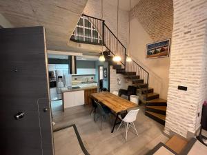 a kitchen and dining room with a table and a staircase at Apartamentos Living Sevilla Centro Maestranza in Seville