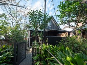 叶山町Hayama Isshiki Beach House -葉山 一色海岸の家 - ペット可的一座带黑色围栏和植物的房子