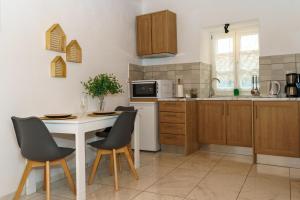 a kitchen with a table and chairs and a microwave at LITTLE YARD - HYDRA DREAM HOUSES in Hydra