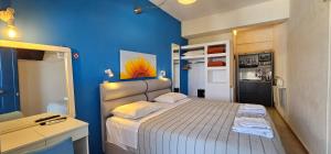 a small bedroom with a bed and a blue wall at Metaxatos Apartments in Lassi