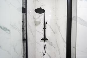 La salle de bains est pourvue d'une douche avec un pommeau de douche. dans l'établissement The 99, Appartement sauna & parking, à Liège