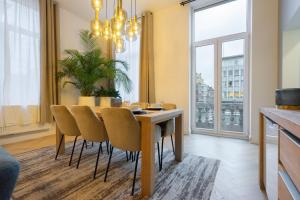 - une salle à manger avec une table et des chaises dans l'établissement The 99, Appartement sauna & parking, à Liège
