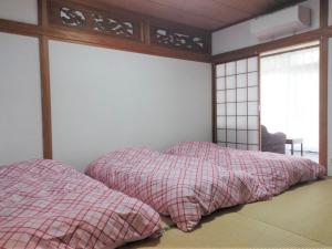 1 dormitorio con 2 almohadas en una cama con ventana en Guest House Asora, en Aso