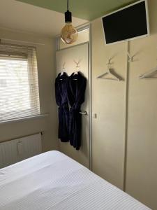 a bedroom with a door with a robe hanging on it at Rose Cottage B&B in Nes